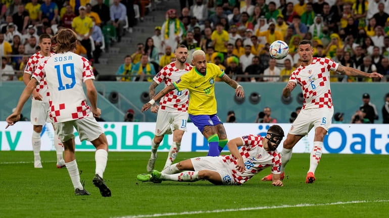 Brazil's Neymar, center, kicks the ball besides Croatia's Josko Gvardiol,...