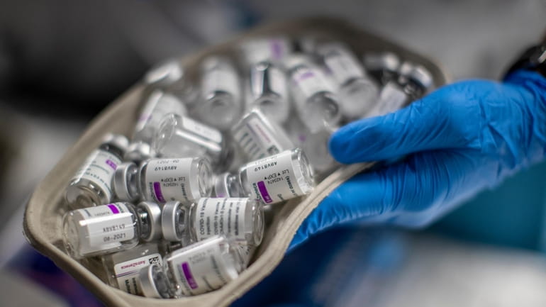 A nurse holds vials of AstraZeneca vaccine against COVID-19 during...