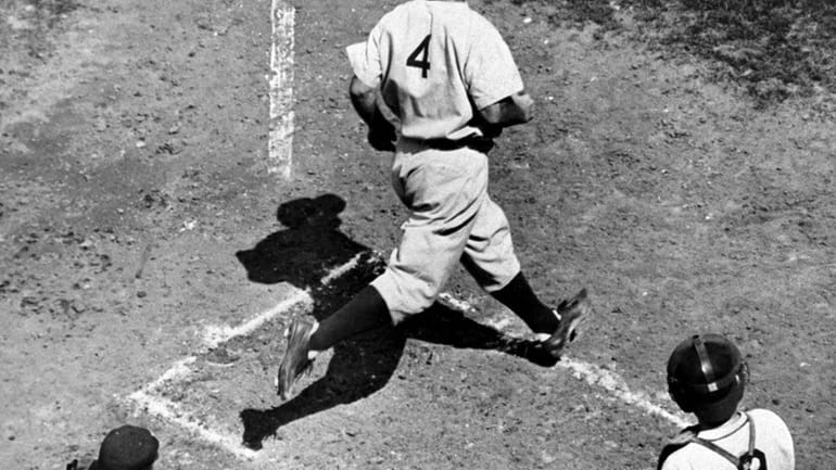 Lou Gehrig, first baseman of the New York Yankees, crosses...
