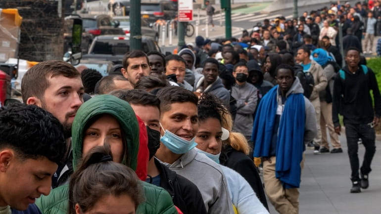 Migrants line up outside of the Jacob K. Javits Federal Building...