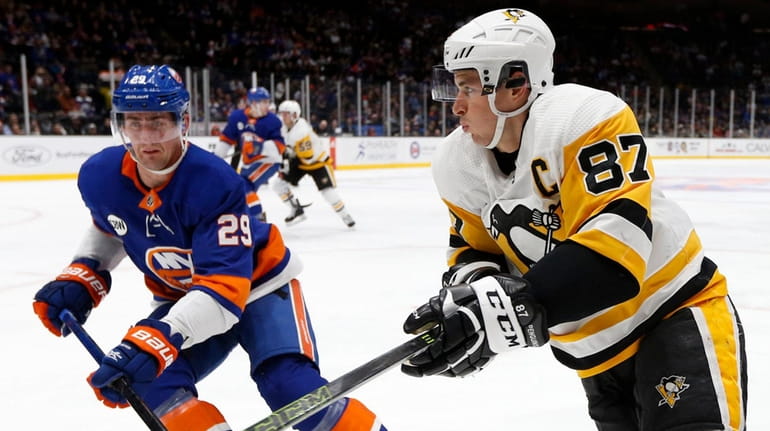 The Penguins' Sidney Crosby skates against the Islanders' Brock Nelson at...