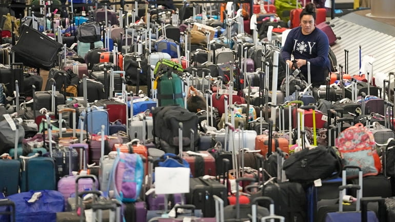 A Southwest Airlines employee looks for an unclaimed bag at...