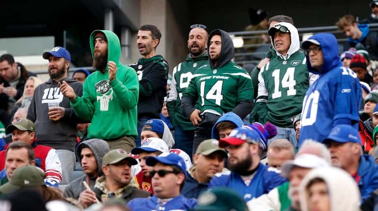 New York Jets and New York Giants fans look on...