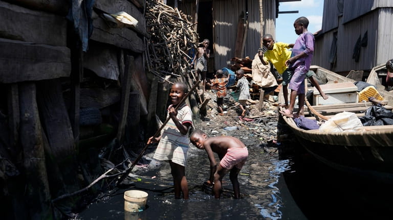Children play in filthy water surrounded by garbage in Nigeria's...