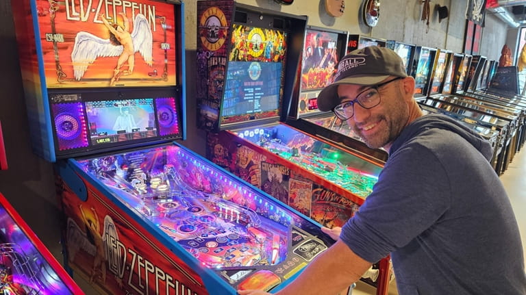 Josh Guskin, owner of Pinball Long Island in Patchogue, demonstrates...