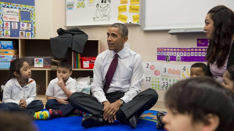 President Barack Obama sits with children during a tour of...