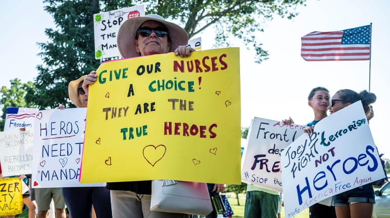 Health care workers and supporters protest against vaccine mandates outside the...