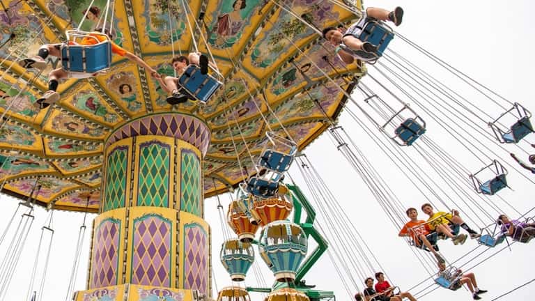 Kids ride amusement park rides at Adventureland on June 21,...
