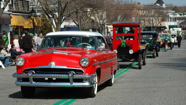 Classic cars drive down Main Street during the St. Patrick's...