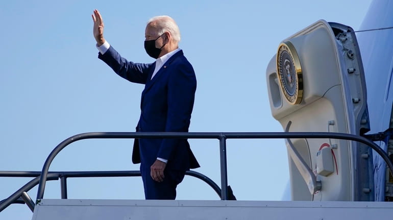 President Joe Biden waves as he boards Air Force One...
