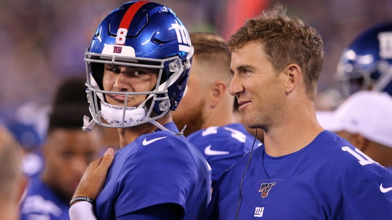Giants quarterback Daniel Jones talks to quarterback Eli Manning on the...