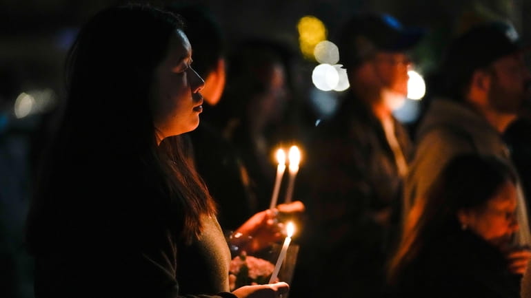 People gather for a vigil honoring the victims of a...