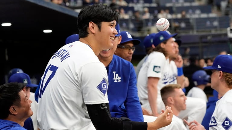 Los Angeles Dodgers' designated hitter Shohei Ohtani smiles during the...