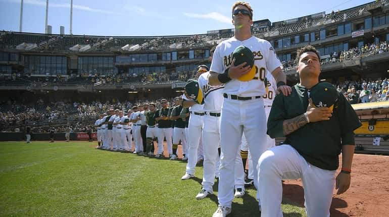 Bruce Maxwell of the Oakland Athletics kneels in protest next...
