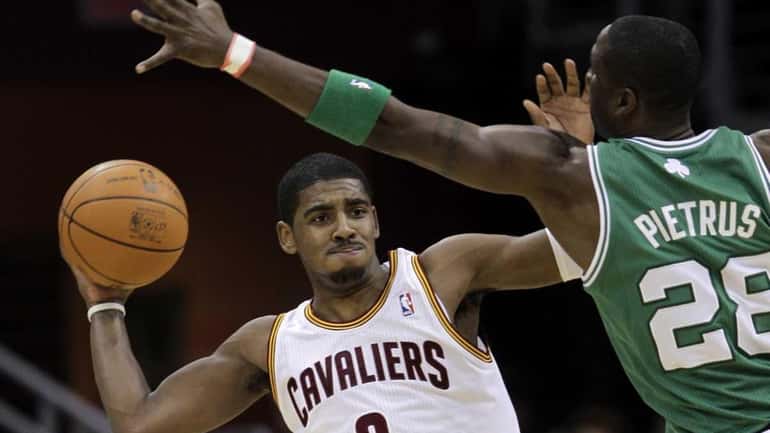 Cleveland Cavaliers' Kyrie Irving (2) passes out under pressure from...
