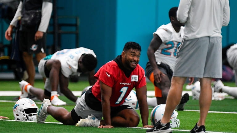 Miami Dolphins quarterback Tua Tagovailoa (1) stretches during practice at...