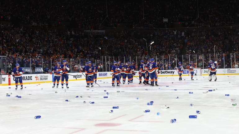 The Islanders wave to the fans as beer cans are...