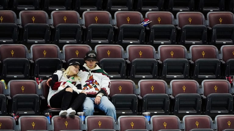 Arizona Coyotes fans sit in their seats long after the...