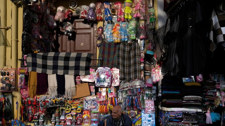 A vendor sits in front of toys displayed for sale...