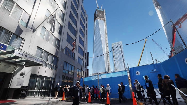 People wait in line to enter the 9/11 Memorial as...