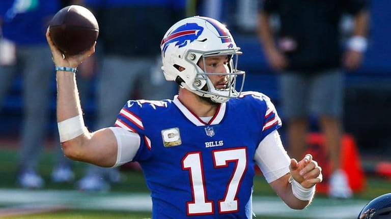 The Bills' Josh Allen throws a pass over the Seahawks'...