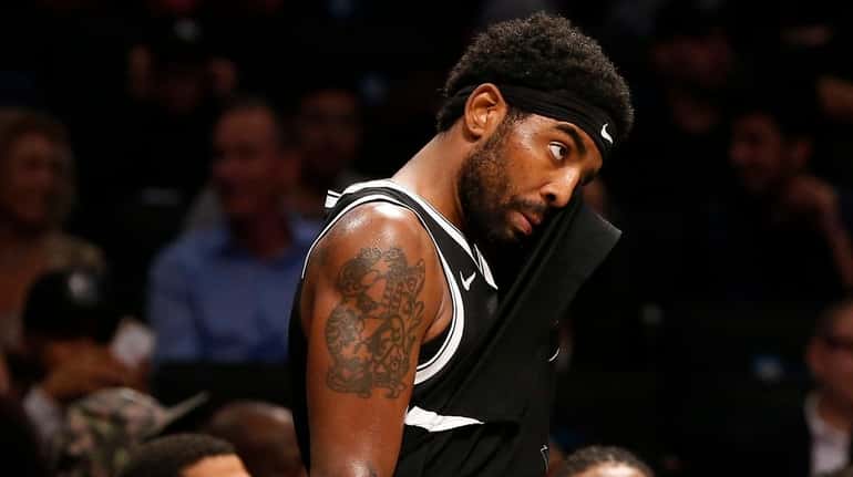 Kyrie Irving of the Nets stands on the sidelines late during...