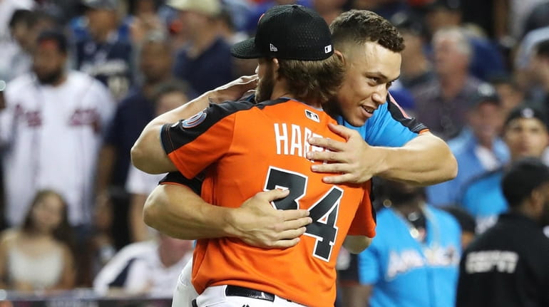 Aaron Judge of the Yankees hugs Bryce Harper of the...