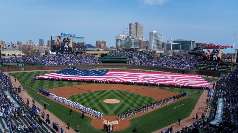 An American flag is unfurled in the outfield before at...