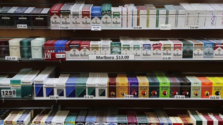Cigarette packs are displayed at a smoke shop in New...