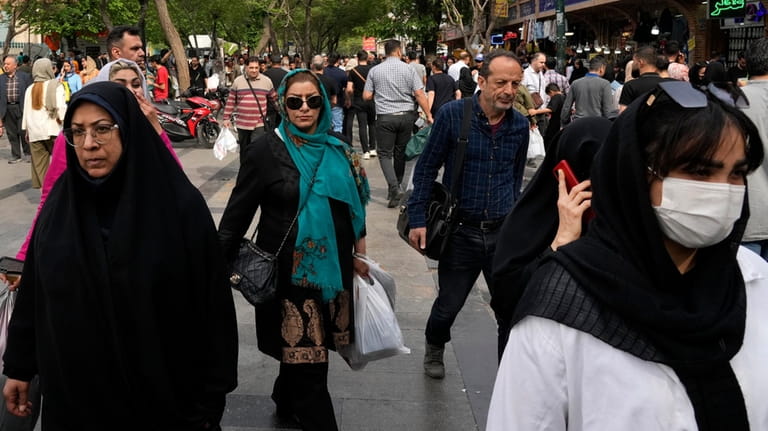 People walk around the old main bazaar in Tehran, Iran,...