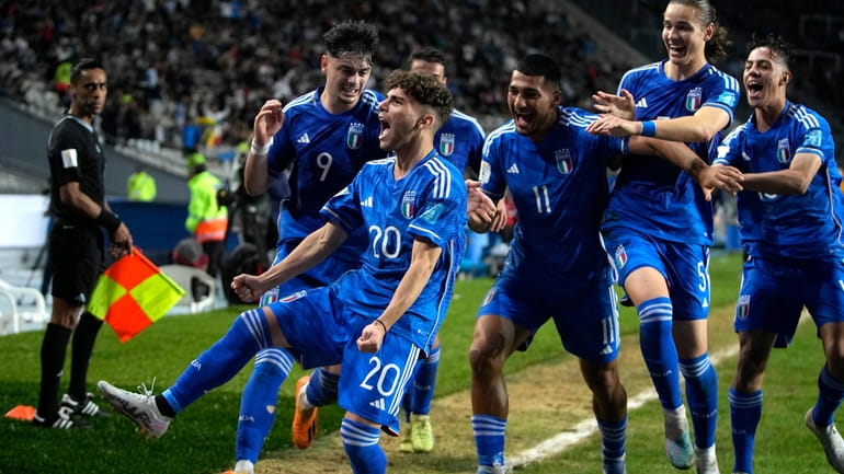 Italy's Simone Pafundi, front, celebrates with teammates after scoring his...
