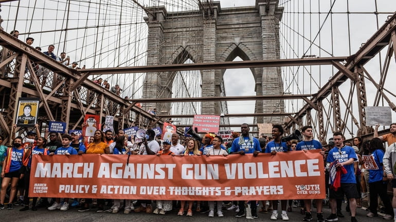 Demonstrators cross the Brooklyn Bridge during a March For Our...