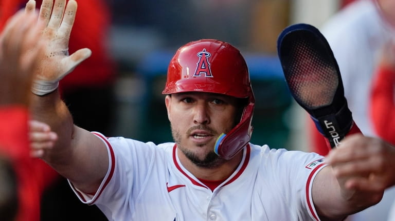 Los Angeles Angels' Mike Trout celebrates in the dugout after...