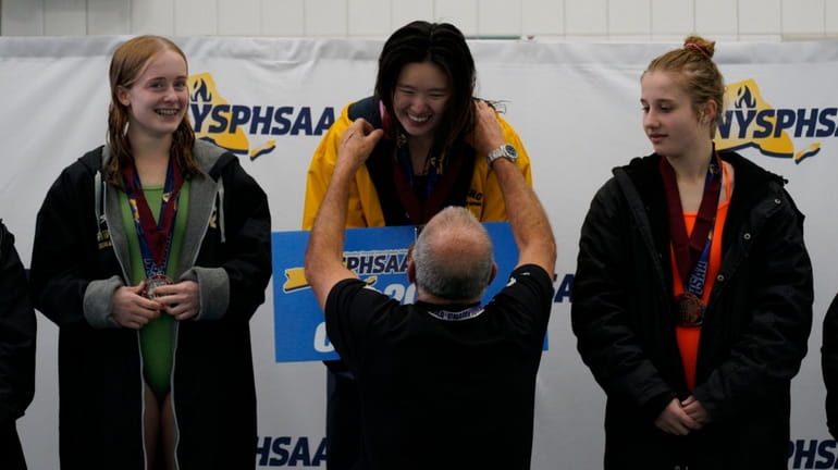 Rachel Yang accepts her first place medal at the state...