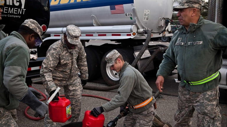 A member of the National Guard fills up a gasoline...