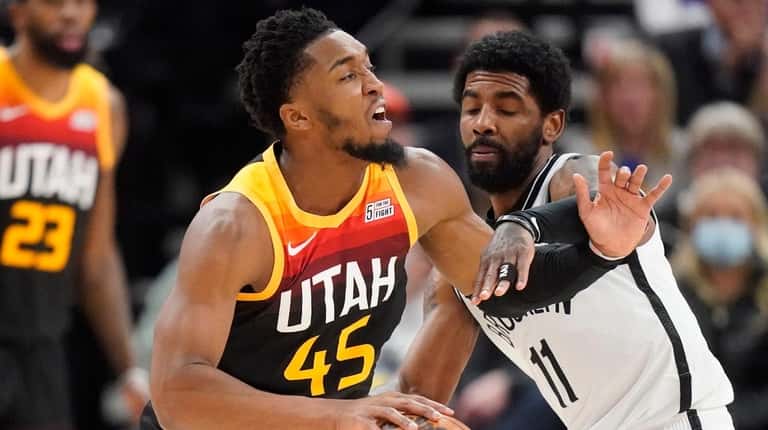 Nets guard Kyrie Irving defends against Jazz guard Donovan Mitchell during the...
