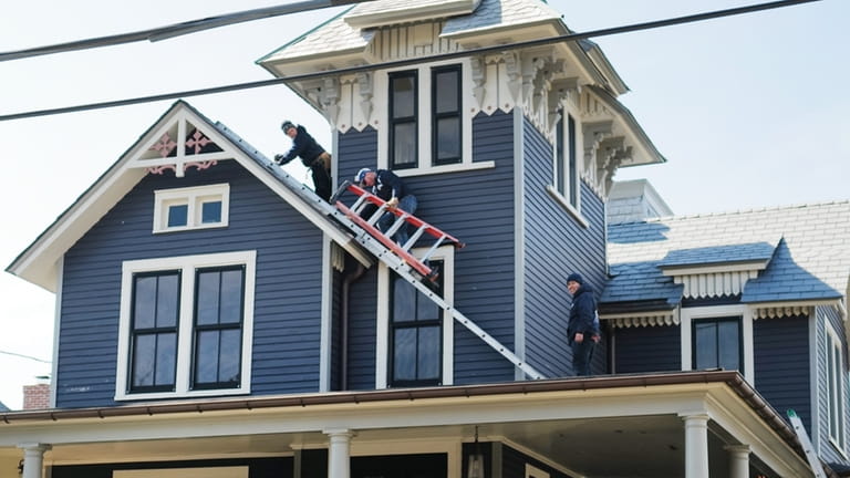 Roofers work Jackie Doyle's Queen Anne Victorian house in Sea Cliff.