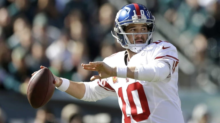 Eli Manning throws a pass during the first half of...