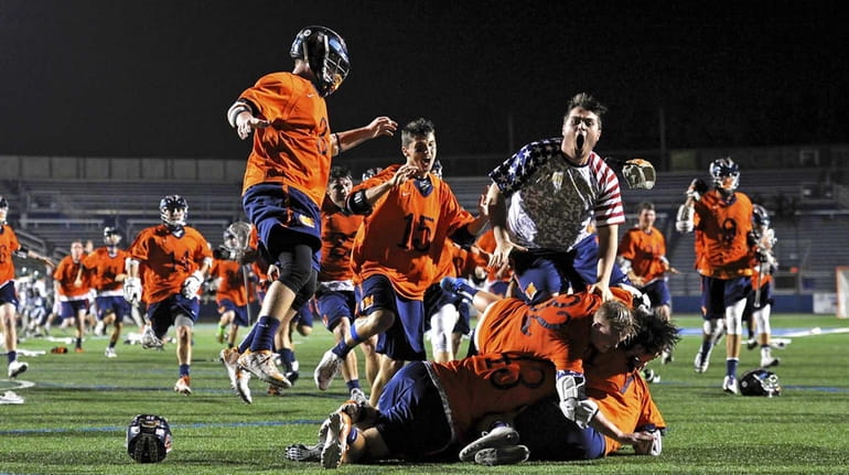 Manhasset rushes its goalie Henry Mulholland after defeating Lynbrook in...