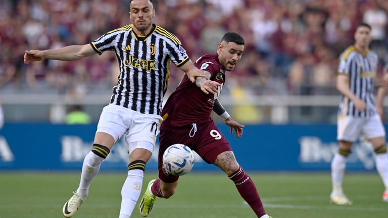 Juventus' Filip Kostic, left, and Torino's Antonio Sanabria vie for...