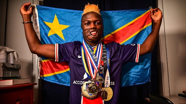 Long Beach wrestler Dunia Sibomana poses with some of his medals...