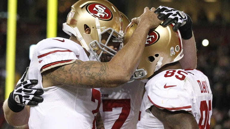 San Francisco 49ers quarterback Colin Kaepernick, left, congratulates tight end...