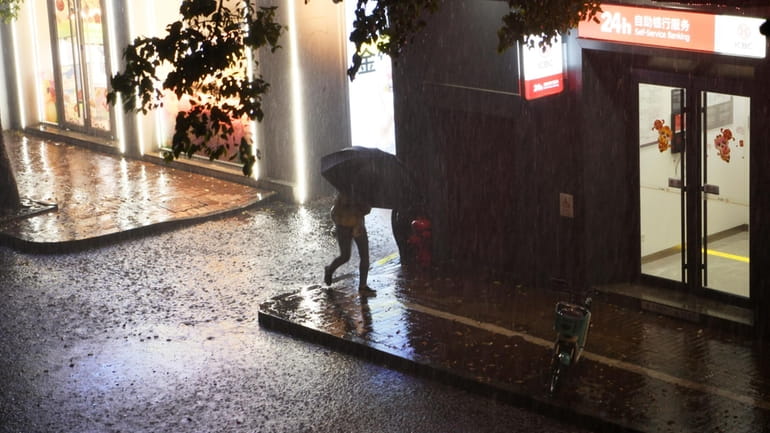 A resident walks through a rain storm in Nanchang in...