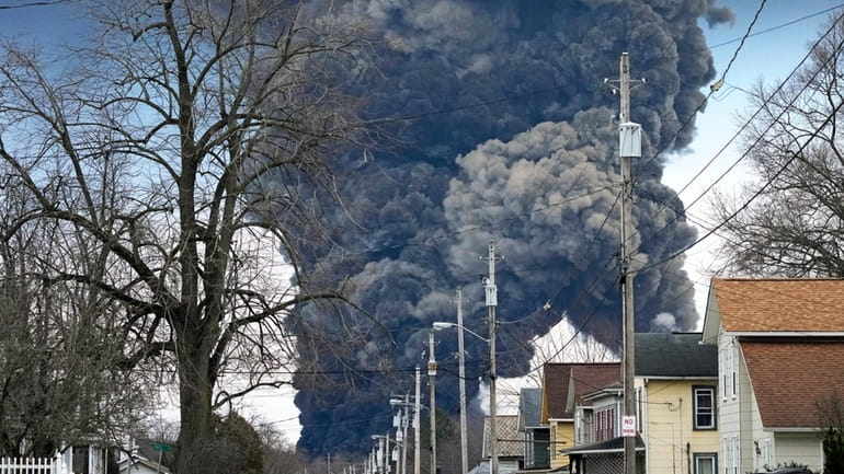 A black plume rises over East Palestine, Ohio, as a...