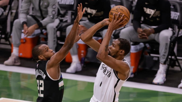 Nets' Kevin Durant shoots against Milwaukee Bucks forward Khris Middleton...