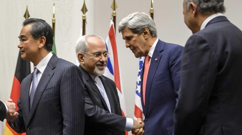 Iranian Foreign Minister Mohammad Javad Zarif shakes hands with US...