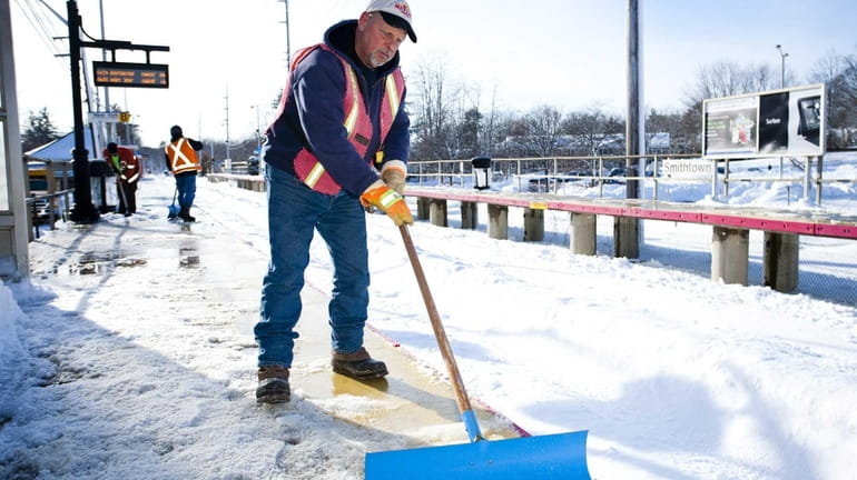 John Metzak clears the snow and ice from the platforms...