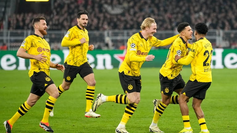 Dortmund's Jadon Sancho, second right, celebrates with teammates after scoring...