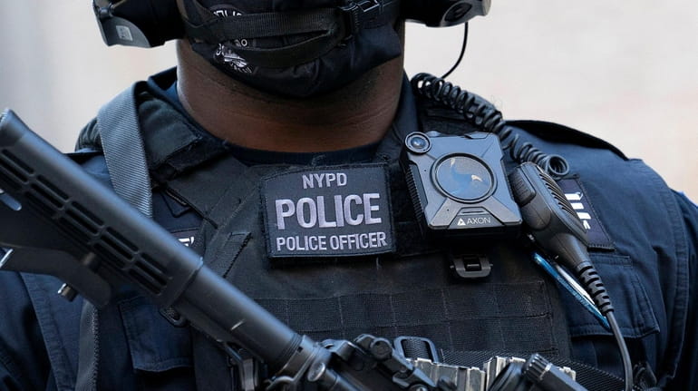 An NYPD officer with a body camera. In its report, the...