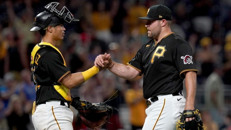 Pittsburgh Pirates relief pitcher David Bednar celebrates with catcher Endy...